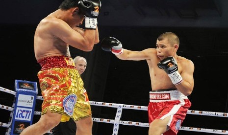   Petinju Chris John (kanan) bertanding melawan petinju Thailand Chonlatarn Piriyapinyo (kiri) memperebutkan Juara Kelas Bulu Super WBA di Singapura, Jumat (9/11) malam. (Antara/Yudhi Mahatma)