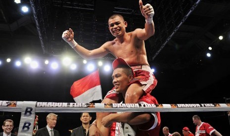    Petinju Chris John merayakan kemenangan usai mengalahkan petinju Thailand Chonlatarn Piriyapinyo di Marina Bay Sands, Singapura, Jumat (9/11) malam. 