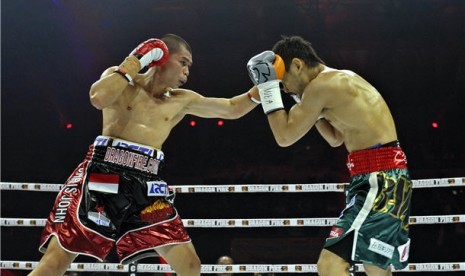  Petinju Indonesia, Chris John (kiri), bertarung melawan Petinju Jepang, Satoshi Hosono, pada perebutan gelar Juara tinju dunia kelas bulu versi WBA, Jakarta, Minggu (14/4) malam. 