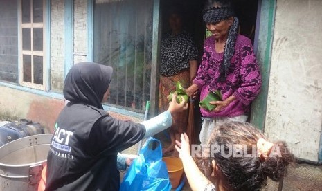 Petugas ACT sedang memberikan bantuan bagi korban banjir