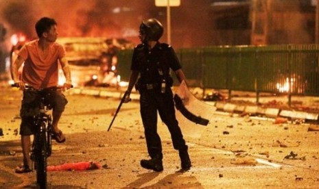 Dua Tewas dalam Kerusuhan di India Akibat Hina Rasulullah. Foto ilustrasi: Petugas antihuru-hara menghalau seorang warga yang melintas di kawasan Little India, Singapura, yang dilanda kerusuhan pada Ahad (8/12/2013)