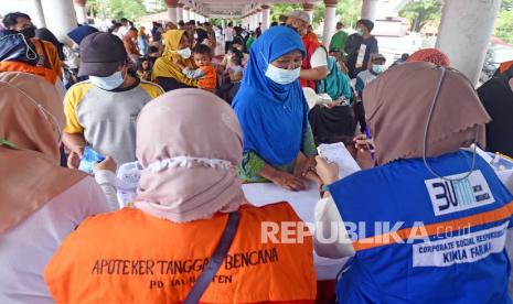 Petugas Apoteker Tanggap Bencana memberikan obat kepada warga saat acara Pengobatan Gratis Untuk Warga Korban Banjir di Alun-alun Serang, Banten, Ahad (13/3/2022). Acara yang digelar Ikatan Dokter Indonesia (IDI) bersama Pemda setempat dimaksudkan untuk membantu pemulihan kesehatan para korban banjir yang sempat terserang beberapa penyakit pasca bencana. 