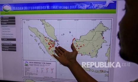 Petugas Badan Meteorologi Klimatologi dan Geofisika (BMKG) Stasiun Kelas I Pekanbaru memperlihatkan peta sebaran titik panas. Ilustrasi