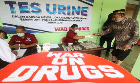 Petugas Badan Narkotika Nasional (BNN) memeriksa urine kepala desa dan aparatur sipil negara (ASN) guna mendeteksi penyalahgunaan narkoba di Kantor Kecamatan Kras, Kediri, Jawa Timur, Rabu (6/10/2021). BNN bekerjasama dengan pemerintah daerah setempat berkomitmen memberantas penyalahgunaan narkoba melalui sosialisasi dan tes urine kepada kepala desa dan ASN guna memberikan jaminan pelayanan maksimal kepada masyarakat.