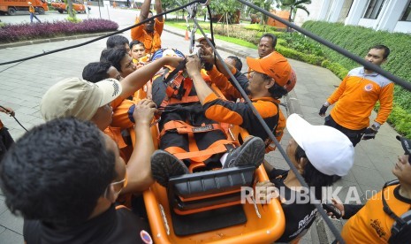 Petugas Badan Nasional Penanggulangan Bencana (BNPB) melakukan evakuasi korban bencana saat glasi bersih simulasi penanganan bencana gempa di Halaman Gedung Sate, Jalan Diponegoro, Kota Bandung, Senin (24/4).