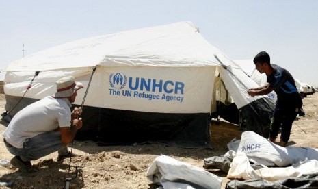  Petugas Badan PBB Urusan Pengungsi (UNHCR) mendirikan tenda pengungsian untuk warga Irak yang mengungsi di kota Erbil, Irak. 