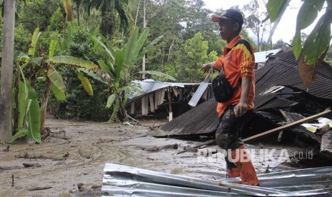 Petugas Badan Penanggulangan Bencana Daerah (BPBD) Agam berada di dekat rumah yang rusak diterjang banjir bandang