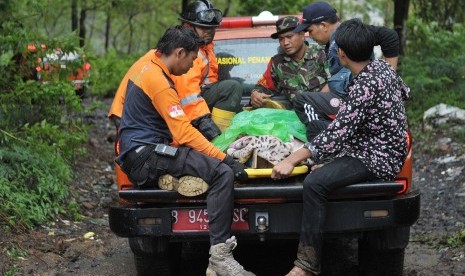 Petugas mengevakuasi warga yang mengalami luka-luka setelah tersapu tanah longsor (ilustrasi) 