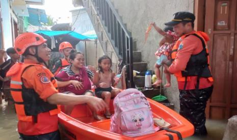 Petugas Badan Penanggulangan Bencana Daerah (BPBD) DKI Jakarta mengevakuasi warga terdampak banjir, Jakarta, Jumat (22/3/2024). 