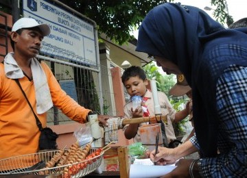 Petugas Badan Pengawas Obat dan Makanan (BPOM) memeriksa makanan (jajanan) yang dijual di lingkungan sekolah, Kampung Bali, Jakarta Pusat, Rabu (14/3). (Republika/Aditya)