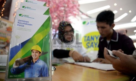 Petugas Badan Penyelenggara Jaminan Sosial (BPJS) Ketenagakerjaan cabang Mangga Dua memberikan informasi kepada masyarakat saat sosialisasi masif BPJS Ketenagakerjaan di ITC Pasar Pagi Mangga Dua, Jakarta, Minggu (29/3).