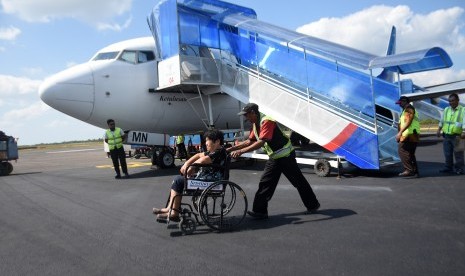 Seribu Warga China Masuk ke Bangka Tiap Tahun. Petugas bandara membantu penumpang lansia menyeberangi landasan saat tiba di Bandara HAS Hanandjoeddin, Belitung, Kepulauan Bangka Belitung. 