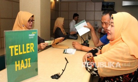 Petugas Bank Mandiri Syariah melayani calon jemaah haji melakukan pelunasan Biaya Penyelenggaran Ibadah Haji (BPIH) di Kantor Cabang Mandiri Syariah Area Bekasi, di Bekasi, Jawa Barat, Senin (16/4). 