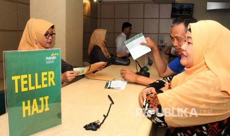 Petugas Bank Mandiri Syariah melayani calon jemaah haji melakukan pelunasan Biaya Penyelenggaran Ibadah Haji (BPIH) di Kantor Cabang BSM di Bekasi, Jawa Barat, Senin (16/4). BSM mulai melayani calon jemaah haji yang melakukan pelunasan BPIH pada 16 April hingga 4 Mei 2018 