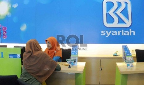 Petugas bank melayani nasabah di kantor BRI Syariah, Jakarta, Rabu (12/8).