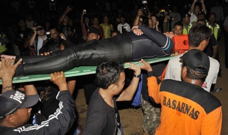 Petugas Basarnas dan nelayan mengevakuasi seorang dari lima wisatawan Jepang yang selamat setelah sempat hilang saat menyelam di Pulau Nusa Lembongan, setibanya di Pantai Semawang, Sanur, Bali, Senin (17/2). 