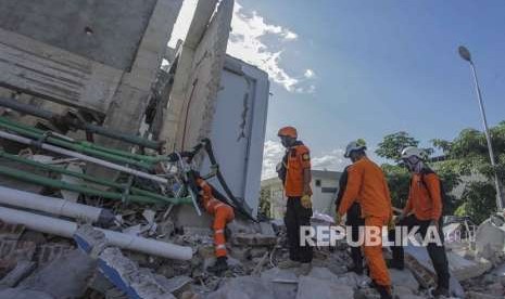 Petugas Basarnas melakukan pencarian korban gempa dan tsunami di Hotel Roa Roa, Palu, Sulawesi Tengah, Ahad (30/9). 