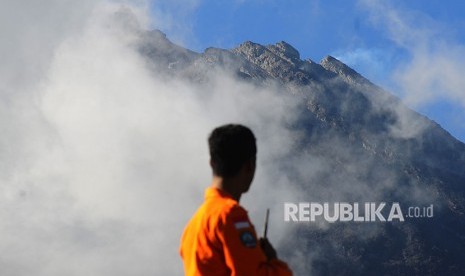 Petugas Basarnas mengamati puncak Gunung Merapi dari Stabelan, Tlogolele, Selo, Boyolali, Jawa Tengah, Selasa (22/5). 