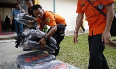 Petugas Basarnas menyiapkan kantung jenazah untuk evakuasi korban penumpang AirAsia QZ 8501, di Pangkal Pinang, Bangka, Selasa (30/12).