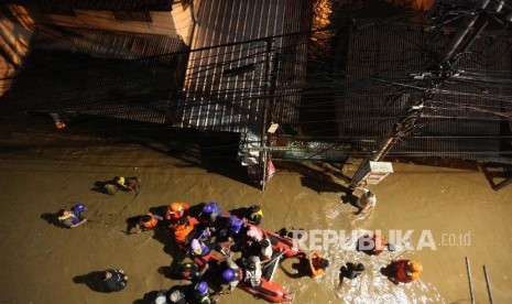 Petugas Basnas melakukan evakuasi warga menggunakan perahu karet saat banjir di kawasan Cililitan, Jakarta, Senin (5/2) malam. Banjir yang merendam kawasan tersebut akibat luapan Kali Ciliwung yang merupakan kiriman dari Bendung Katulampa, Bogor.