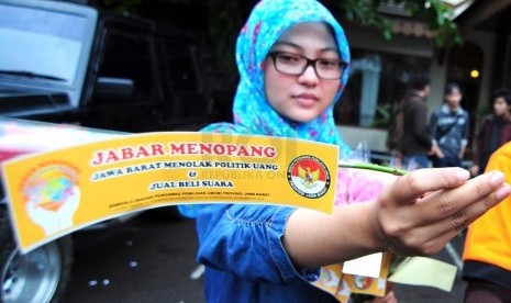 Petugas Bawaslu Jabar memperlihatkan bunga dan stiker sebagai bentuk sosialisasi pemilu bersih di Jalan Surapati, Bandung, Kamis(27/3).  (foto: Septianjar Muharam)