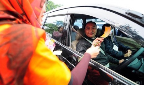   Petugas Bawaslu Jabar memperlihatkan bunga dan stiker sebagai bentuk sosialisasi pemilu bersih di Jalan Surapati, Bandung, Kamis(27/3).  (foto: Septianjar Muharam)