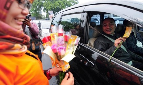   Petugas Bawaslu Jabar memperlihatkan bunga dan stiker sebagai bentuk sosialisasi pemilu bersih di Jalan Surapati, Bandung, Kamis(27/3).  (foto: Septianjar Muharam)