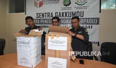 Petugas Bawaslu Jakarta Pusat menunjukkan kardus berisi ribuan form C1 Pemilu yang diamankan polisi dari sebuah mobil yang melaju di kawasan Menteng, Jakarta, di Gedung Bawaslu Jakarta Pusat, Senin (6/5/2019). 