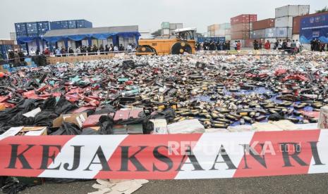 Petugas Bea Cukai menggunakan alat berat saat memusnahkan minuman dan rokok ilegal di Tempat Penimbunan Pabean (TPP), Cikarang, Kabupaten Bekasi, Jawa Barat, Rabu (22/12/2021). Direktorat Jenderal Bea dan Cukai bersama Kejaksaan Negeri Tigaraksa Kabupaten Tangerang memusnahkan sebanyak 2.626.375 rokok ilegal, 33.810 botol minuman mengandung Etil Alkohol (MMEA), 553 tembakau, 262 lembar pita cukai palsu dan 141 rol tekstil senilai Rp15,6 miliar. 