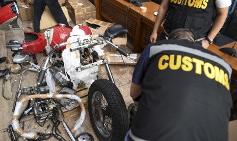 Petugas Bea Cukai menyiapkan barang bukti pada konferensi pers terkait penyelundupan motor Harlery Davidson dan sepeda Brompton menggunakan pesawat baru milik Garuda Indonesia di Kementerian Keuangan, Jakarta, Kamis (5/12).