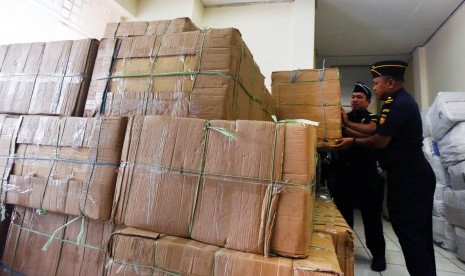 Petugas Beacukai merapikan kardus berisi rokok ilegal hasil sitaan di Kantor Beacukai Sulsel di Makassar, Sulawesi Selatan, Senin (10/4).