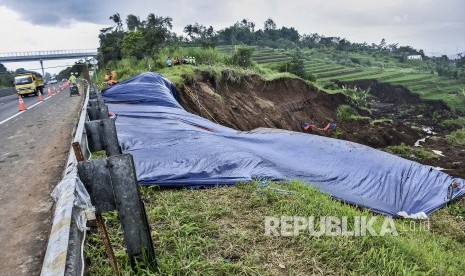 Petugas berada di area pemasangan perkuatan lereng di lokasi pergerakan tanah yang menyebabkan longsor di KM 118 Tol Cipularang, Kabupaten Bandung Barat, Senin (17/2).