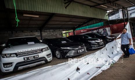 Petugas berada di dekat kendaraan sitaan milik tersangka kasus dugaan korupsi PT ASABRI (Persero) di Kantor Pusat PT ASABRI (Persero), Cawang, Jakarta, Sabtu (12/6/2021). Kejaksaan Agung melelang 16 mobil kelas menengah hingga mewah hasil sitaan terkait kasus dugaan korupsi PT ASABRI (Persero) yang akan dilakukan pada 15 Juni 2021 pukul 09.00-11.00 WIB pada laman www.lelang.go.id. 