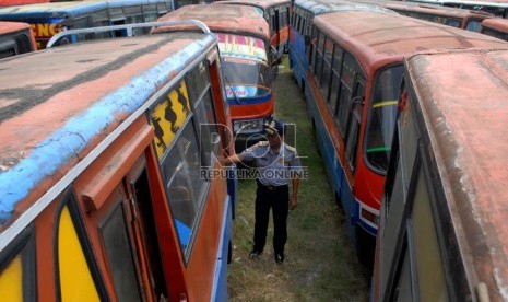   Petugas berada diantara puluhan metromini dengan kondisi tidak layak jalan terparkir di Terminal mobil barang Pulo Gebang , Jakarta Timur, Kamis (30/8). (Republika/Rakhmawaty La'lang)