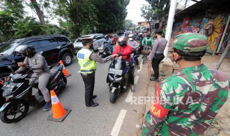  Petugas berjaga di pos pemeriksaan selama pembatasan kegiatan darurat masyarakat (PPKM) di ruas jalan Lenteng Agung di pos pemeriksaan selama pemberlakuan pembatasan darurat COVID-19 di Jakarta, 21 Juli 2021. Pemerintah Indonesia memperpanjang Pembatasan Kegiatan Darurat Masyarakat (PPKM) hingga 26 Juli 2021.