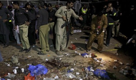 Petugas berkerumun di lokasi ledakan di sebuah taman di Lahore, Pakistan, Senin (28/3).