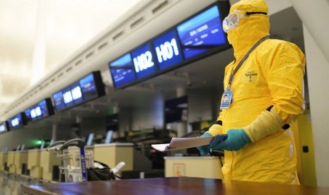 Petugas berpakaian pelindung lengkap berdiri di ruang check in di Wuhan Tianhe International Airport, Kota Wuhan, Provinsi Hubei, China. Maskapai penerbangan China melaporkan kerugian 4,8 miliar dolar AS akibat pandemi corona. Ilustrasi.