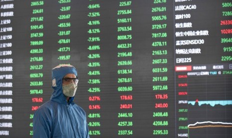 Petugas berpelindung lengkap berjalan di lobby Gedung Shanghai Stock Exchange, Senin (3/2). Saham-saham China dibuka menguat pada perdagangan Senin (16/11) pagi, rebound dari kerugian akhir pekan lalu. 