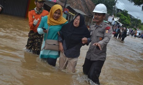 Petugas bersama relawan membantu mengevakuasi korban banjir di Pasar Labuan, Labuan, Pandeglang, Banten, Selasa (1/1/2019).