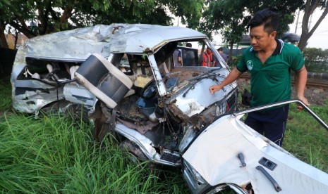 Petugas bersiap memindahkan mobil Mitsubisi L300 bernopol P 1264 DE yang ringsek akibat kecelakaan dengan kereta api di lintasan rel di Dusun Rohkepuh, Beji, Pasuruan, Jawa Timur, Rabu (9/1/2019).