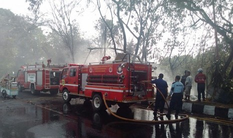 Petugas berusaha memadamkan api di lokasi kebakaran barang bekas di Ciluar, Bogor,Selasa (27/10).