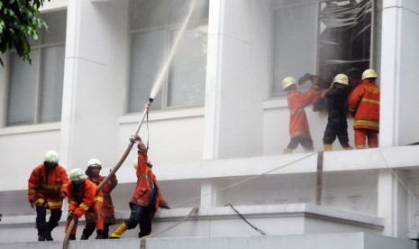   Petugas berusaha memadamkan api kebakaran yang melanda lantai tiga Gedung Sekretariat Negara di Komplek Istana Kepresidenan, Jakarta, Kamis (21/3) sore.