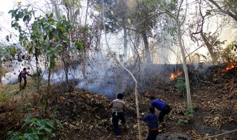  Petugas berusaha memadamkan api yang membakar kawasan hutan di Desa Bili-Bili, Kecamatan Bontomarannu, Kabupaten Gowa, Sulawesi Selatan, Kamis (1/10). 