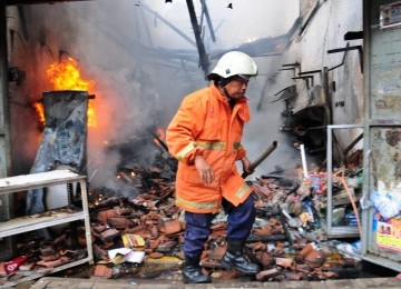 Petugas berusaha memadamkan kebakaran yang melanda delapan rumah toko (ruko) di Jalan Palmerah Barat, Jakarta Barat, Rabu (7/3). (Republika/Aditya Pradana Putra)