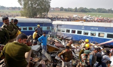 Petugas berusaha mengeluarkan korban kecelakaan kereta api di India, Ahad (20/11).