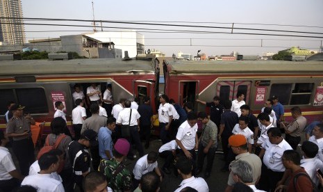 Petugas berusaha mengevakuasi barang dan penumpang yang ada di gerbong ketika terjadi tabrakan Kereta Rel Listrik (KRL) di Stasiun Juanda, Rabu (23/9).