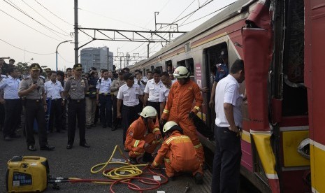 Petugas berusaha mengevakuasi masinis yang terjepit di gerbong ketika terjadi tabrakan Kereta Rel Listrik (KRL) di Stasiun Juanda, Rabu (23/9). 