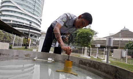   Petugas BMKG mengecek tingkat penguapan air menggunakan alat evaporimeter di Stasiun Meteorologi 745, Kemayoran, Jakarta Pusat, Senin (5/11).    (Adhi Wicaksono)