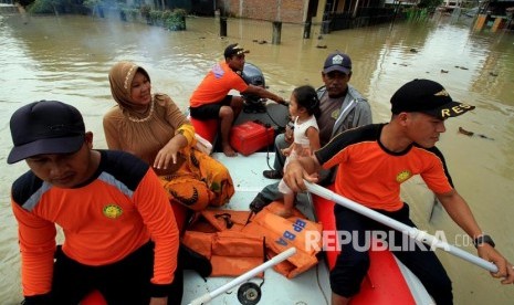 Petugas BNPB mengevakusi warga di tengah banjir di Lhoksukon, Aceh Utara, Aceh, Senin (4/12)