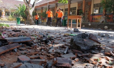 Petugas BPBD Badung memeriksa kondisi bangunan SD No. 1 Ungasan yang rusak di bagian atap akibat gempa bumi di Badung, Bali, Selasa (16/7/2019).